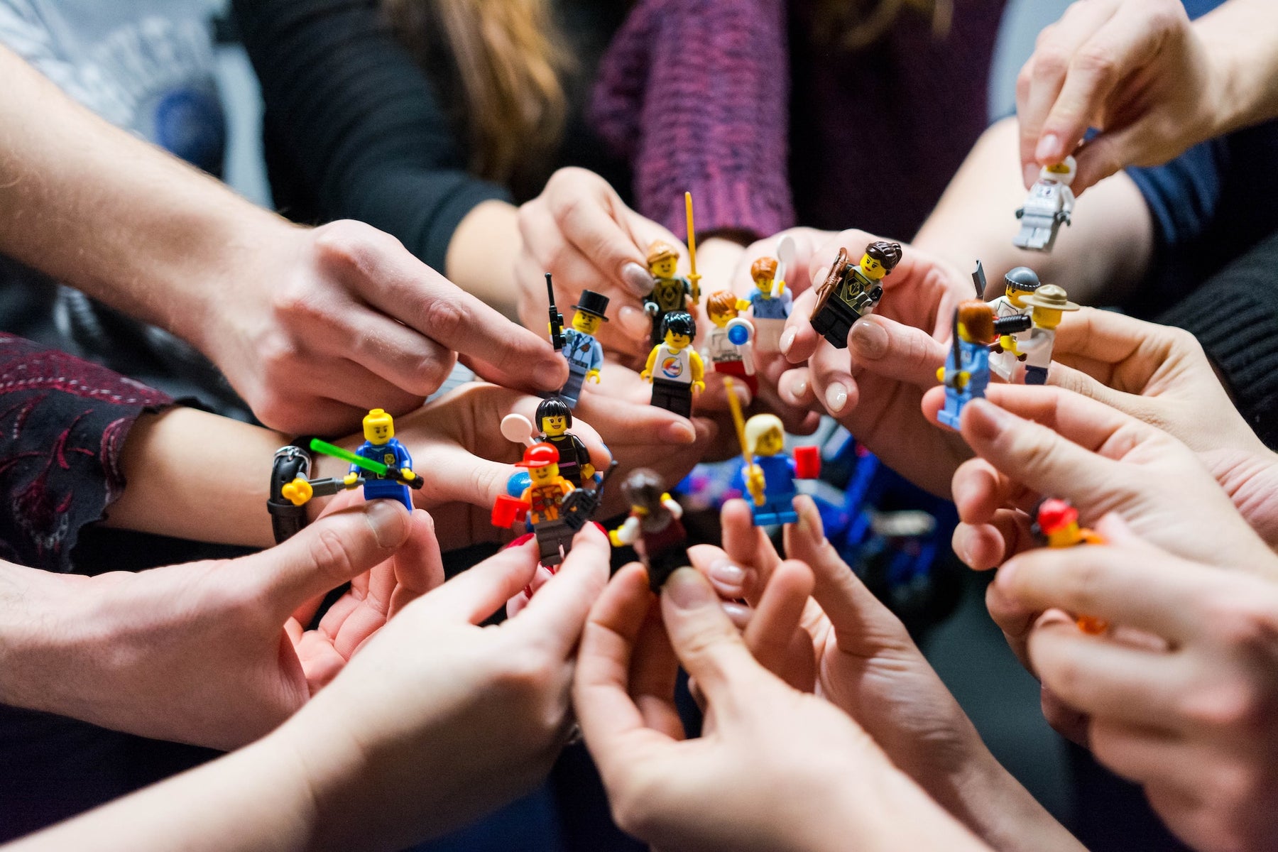 Hands holding different minifigures